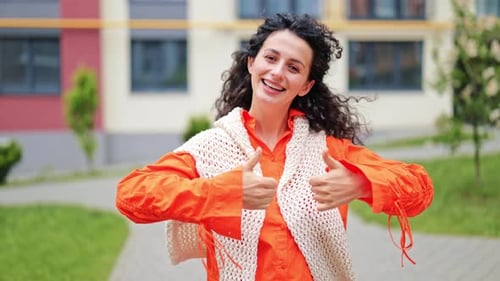 Woman Gives Thumbs Up Outside Apartment Building