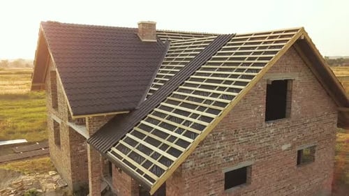 Aerial View of Unfinished House with Wooden Roof Structure Covered with Metal Tile Sheets Under