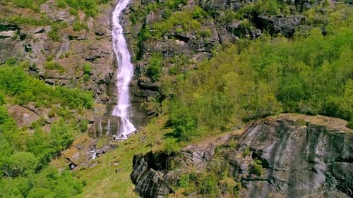Waterfall on a cliff in a mountain forest - aerial view