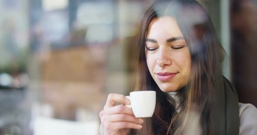 One morning a beautiful elegant woman eats breakfast at the outdoor bar with a coffee and croissan