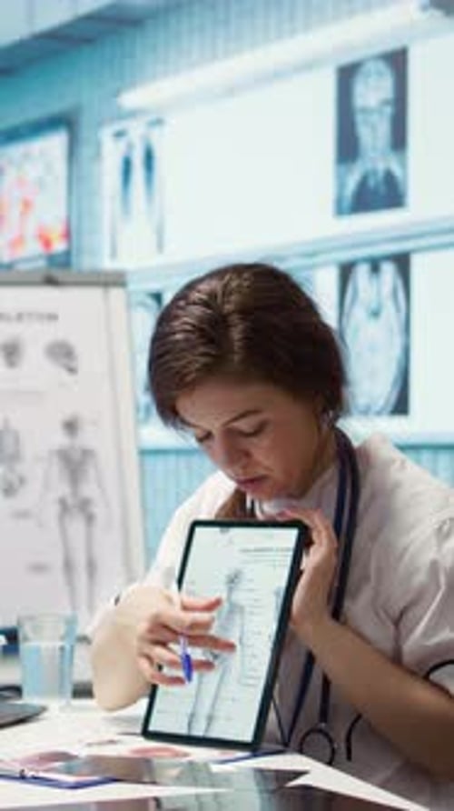 Female Doctor Explains Skeleton Diagram on Tablet