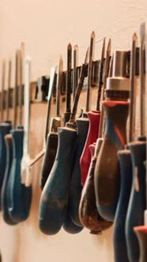 Vertical Video Chisels Screwdrivers Wrench and Pliers on Wall in Furniture Assembly Shop