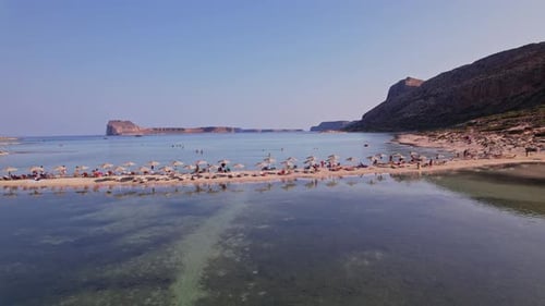 Beautiful beach with sunbathers and umbrellas on a clear day in Crete