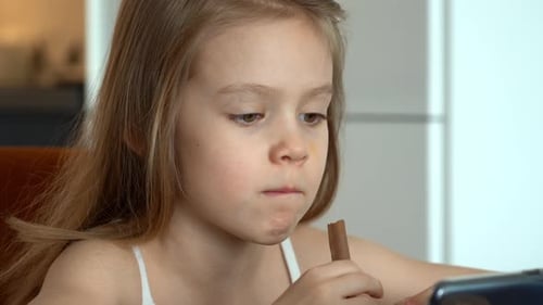 Little Girl Eating Chocolate Snack Stick