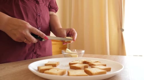 Person Spreading Butter on Square Pieces of Toast