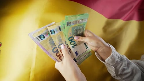 Spanische Flagge im Hintergrund Frau zählt Geld, Euro, Kredite, Erhöhung der Zölle in der EU, Europa, Reisen