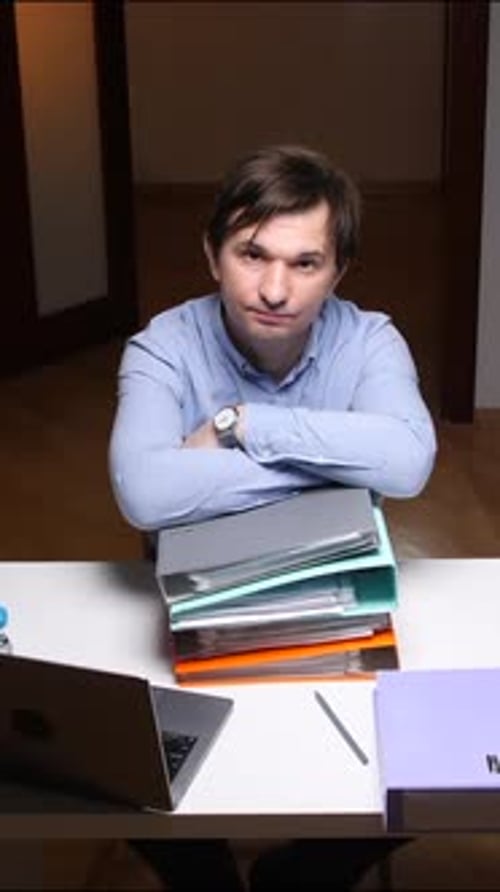 Vertical Video Office Worker Putting Binders on Desk at Night