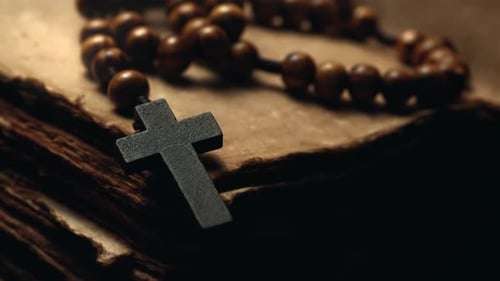 Cross and Rosary Lying on Old Book