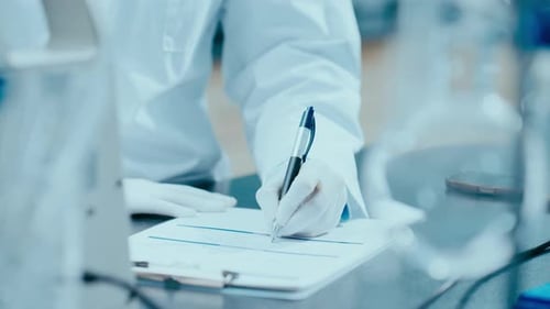 Woman Scientist Writes on Clipboard in Lab