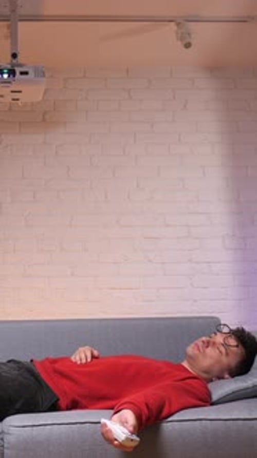 Adult Lying on Couch Under Projector