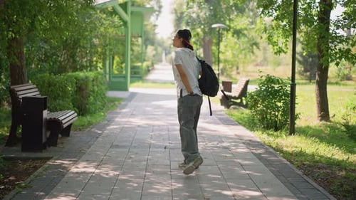 Teenage Amble in Calm Park Youth Casually Wandering Beneath Leafy Shade Young Man Leisurely Strolls