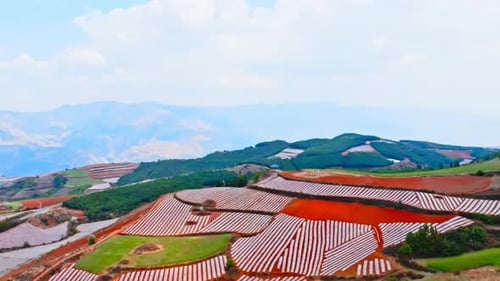 Overhead view of large agricultural lands with corn, wheat and sunflower fields and red mountains