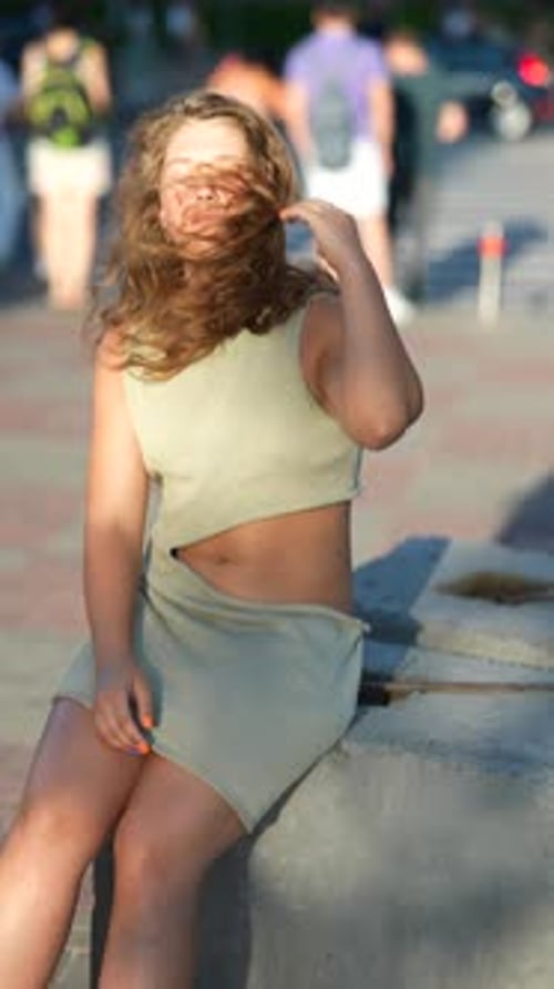 Woman Sits on Concrete in Public Urban Space