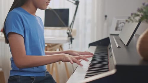 Close up of Asian child playing electronic piano in music record studio