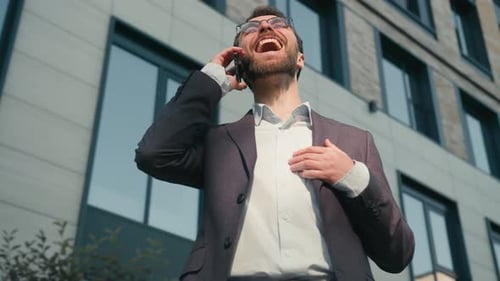 Happy Man Talking on Phone Outside Office Building