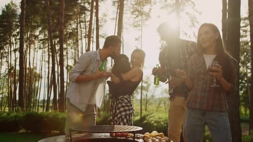 Friends Enjoying Outdoor Barbecue Party in Sunny Forest