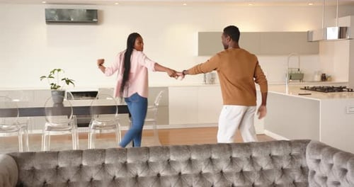 Young Couple Joyfully Dancing Together at Home