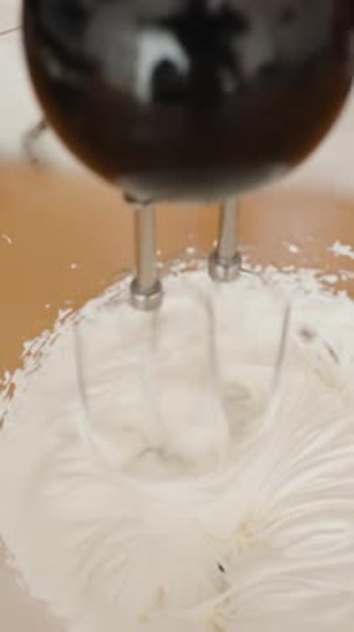 White Cream Mixing with Electric Mixer in Bowl