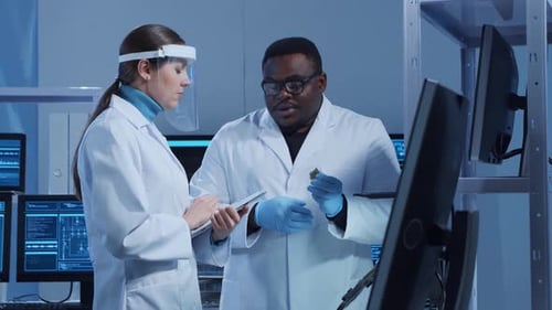 Scientists Discuss Electronic Component in Modern Laboratory