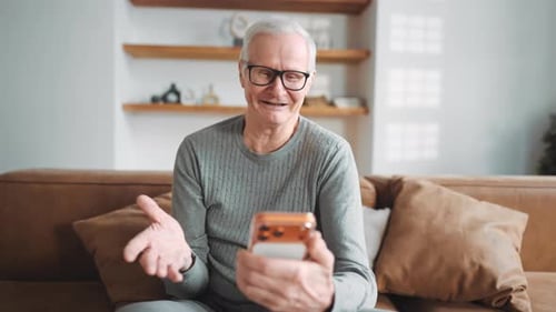 Senior Man Video Calling on Smartphone at Home