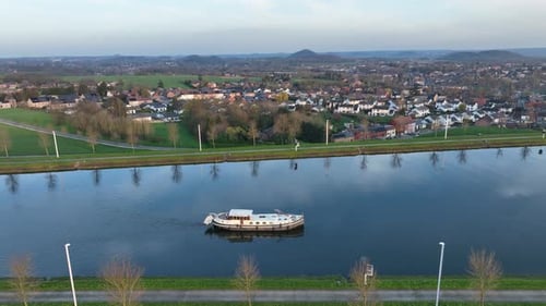 Semi orbit showing boat cruising along the Strépy-Thieu canal at golden hour