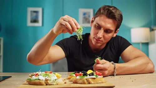 Young Man Preparing Open-Faced Sandwiches in Kitchen