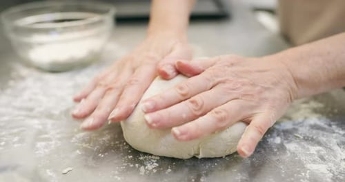 4k video footage of an unrecognizable baker shaping dough in a bakery