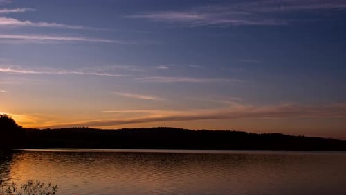 A sunset over a lake in the summer.