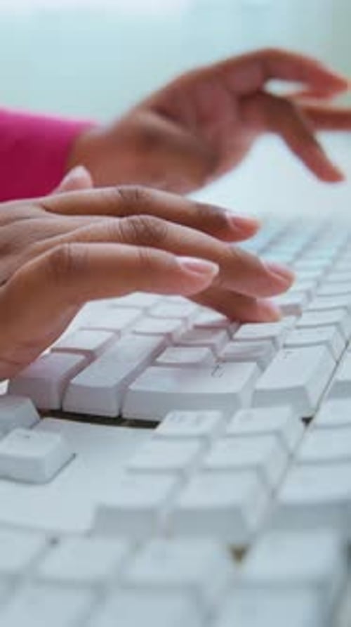 Les mains tapent sur un clavier avec une concentration concentrée dans un environnement de travail lumineux