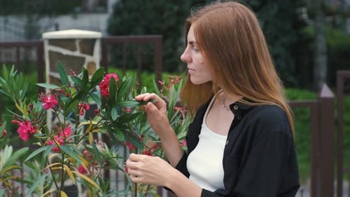 Alone Beautiful Young Woman Enjoying Beautiful Flowers in Her Garden Near Her House