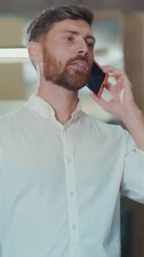Man Talking on Phone in Modern Workplace