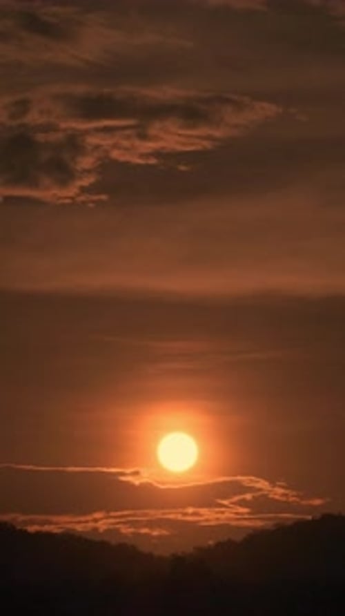 Timelapse of dramatic sunrise with orange sky in a sunny day.