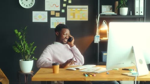 Young Black Businessman Having Phone Talk at Office Workplace