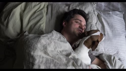 Man Sleeping in Bed with Dog Companion
