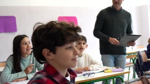Cheerful Teacher Helping Students in Bright Classroom
