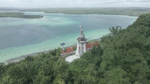 Vista aérea de la estatua de Jesús con hermosa vista a la playa en la isla de Molucas, Indonesia