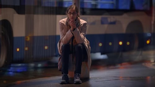 Woman Sitting on City Street at Night