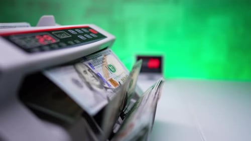 Money counting machine counts hundred dollar bills