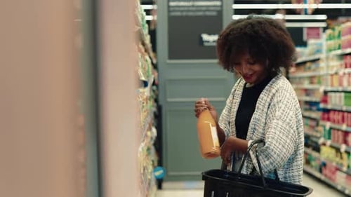 Portrait of Smiling African American Lady Taking Juices From Supermarket Shelf