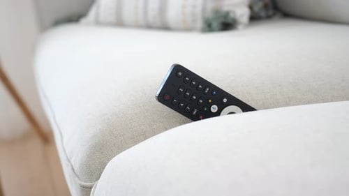 Modern Television Remote on Comfortable Couch in Home