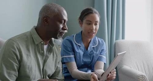 Female Nurse Using Tablet with Senior Man