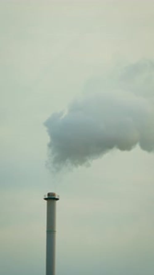 Industrial Chimney Emitting Smoke Against Overcast Sky, Vertical