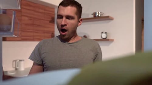 Young Adult Eating Sandwich from Inside Refrigerator