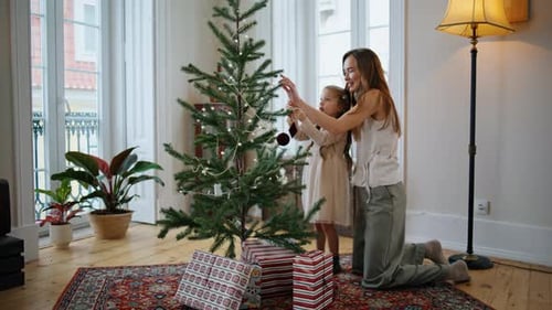 Cheerful Mother Daughter Decorating Christmas Tree Home