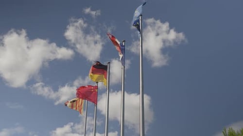 Flags of Multiple Countries Waving Against Cloudy Sky