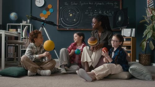 Teacher Explains Solar System to Students with Planet Models