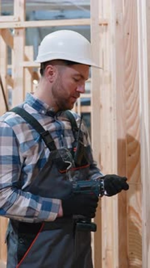 Trabajador de la construcción ensamblando un marco de casa modular de madera