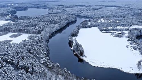 River and snowy forest in winter. Aerial view of nature