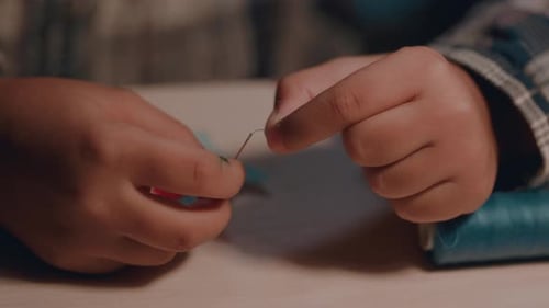 A Schoolage Girl Makes a Craft with Her Own Hands in Her Room at Home