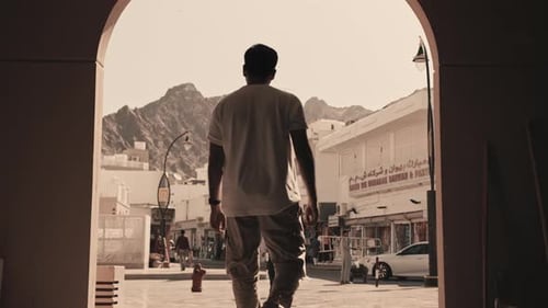 Man Standing and Looking at Mountain and City Landscape